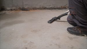 Why Might Concrete Appear Red or Chalky Under an Old Floor Leveling Layer?